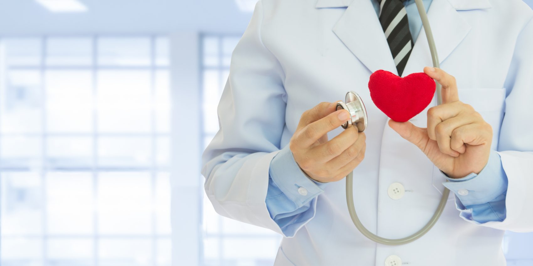 Dentist holding a stethoscope and heart, for a preventative dental health plan contact St. John dentist.